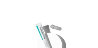 site-industries-cosmetiques Un tube de crème pour les yeux avec la micro spatule Squeeze'n brevetée de Dermalogica de Cosmogen, placé sur un fond blanc.