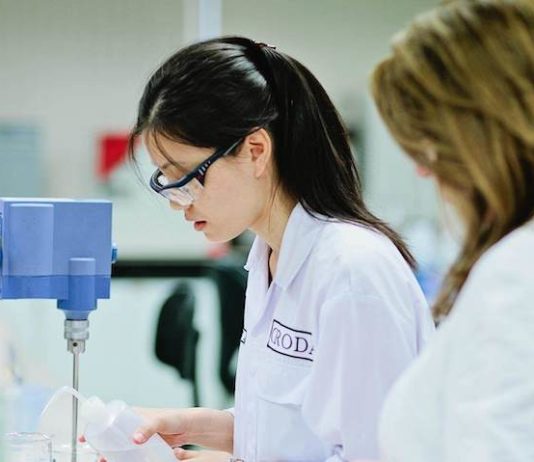 site-industries-cosmetiques Deux femmes en blouse de laboratoire travaillant dans un laboratoire.