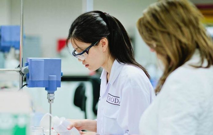 site-industries-cosmetiques Two women in lab coats working in a laboratory.