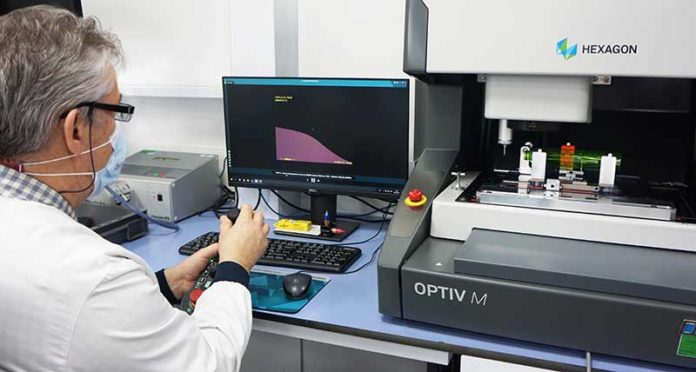 site-industries-cosmetiques A man in a laboratory performing precise dimensional checks on L'Oréal bottles and capsules.