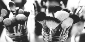 site-industries-cosmetiques Une photo monochrome de pinceaux de maquillage dans un récipient.