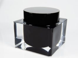 site-industries-cosmetiques 制作一个白色表面上带有透明盖子的黑色墨水瓶。