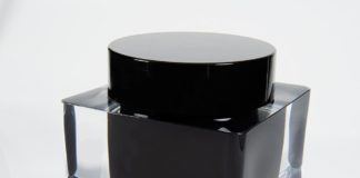 site-industries-cosmetiques Fabrication d'un flacon d'encre noire avec un couvercle transparent sur une surface blanche.