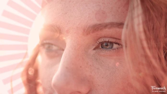 site-industries-cosmetiques A woman with a radiant face wearing an uplifting pink perfume.