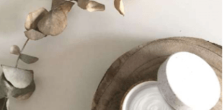 site-industries-cosmetiques Un bol de crème blanche posé sur un morceau de bois biologique.