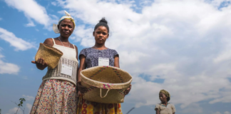 site-industries-cosmetiques Deux femmes tenant des paniers dans un champ dans le cadre de l'initiative "Action pour la Nature & les Hommes" soutenue par Seppic et l'UEBT.