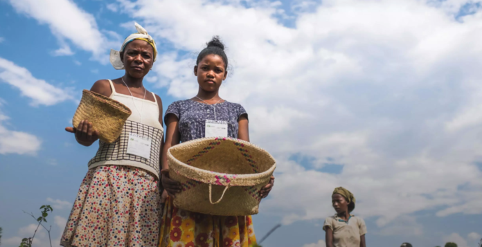 site-industries-cosmetiques Two women holding baskets in a field as part of the 