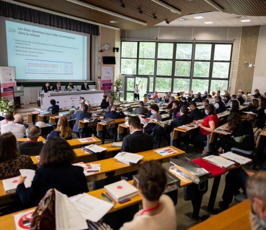 site-industries-cosmetiques Une salle remplie de gens assis à des bureaux, concentrés sur la revitalisation et la résilience de l’industrie de la Cosmetic Valley.