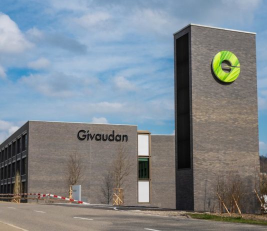 site-industries-cosmetiques Un bâtiment avec une enseigne verte devant est acquis par Givaudan.
