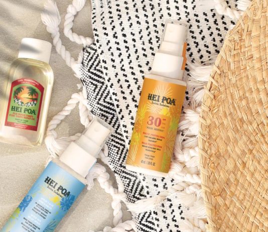 site-industries-cosmetiques Une bouteille de crème solaire et un chapeau de paille sur une plage de Tahiti.