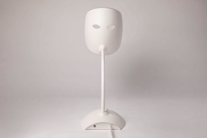 site-industries-cosmetiques A white lamp with an LED face mask.