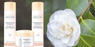 site-industries-cosmetiques Une fleur blanche avec une bouteille de démaquillant huile au camélia à côté.