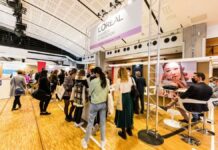 site-industries-cosmetiques Un grupo de personas delante de un quiosco, rodeadas de carteles de proyectos.