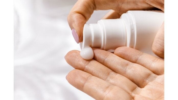 site-industries-cosmetiques A woman's hand holds a bottle of Lubrizol cream.