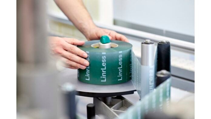 site-industries-cosmetiques A person inserts a roll of paper into an automatic machine.