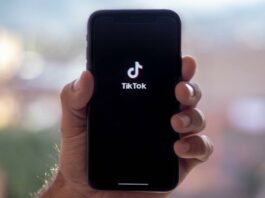 site-industries-cosmetiques Une personne présentant un téléphone arborant le logo tiktok.