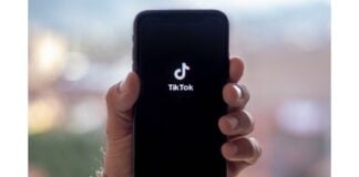 site-industries-cosmetiques Una persona sostiene un teléfono con el logotipo de tiktok.