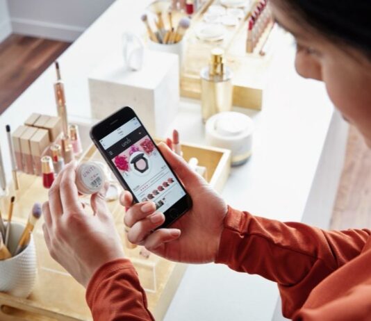 site-industries-cosmetics Una mujer usa su teléfono para mirar cosméticos.