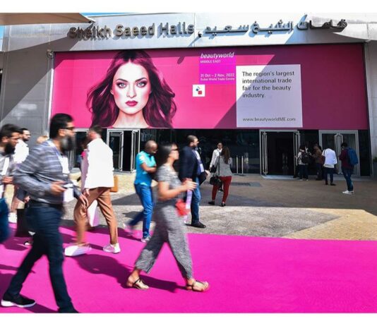 site-industries-cosmetiques A group of people walking in front of a pink building, captured by Brouillon auto.