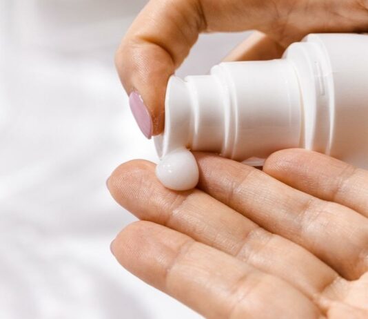 site-industries-cosmetiques 一名妇女手拿一瓶化妆品。