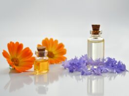 site-industries-cosmetiques Huiles essentielles et fleurs sur une surface blanche. L'arôme délicat de ces huiles essentielles et les couleurs vibrantes des fleurs créent une ambiance apaisante dans n'importe quel espace. Qu'il soit utilisé pour la détente ou comme