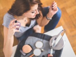 site-industries-cosmetiques Una mujer maquillada está sentada sobre una mesa.