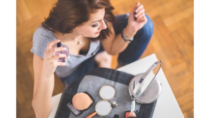 site-industries-cosmetiques A woman wearing make-up sits on a table.