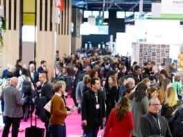 site-industries-cosmetiques 在熙熙攘攘的新创企业室内展厅里，常常佩戴着徽章的一大群人漫步其中。展台和展品鳞次栉比，展示着 2025 年巴黎包装周的创新成果。地板上铺着粉红色的地毯，在繁忙的 "发现 "展区，天花板上悬挂着横幅。