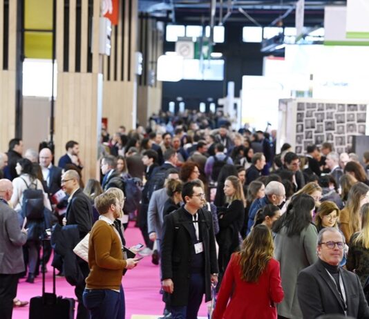 site-industries-cosmetiques 在熙熙攘攘的新创企业室内展厅里，常常佩戴着徽章的一大群人漫步其中。展台和展品鳞次栉比，展示着 2025 年巴黎包装周的创新成果。地板上铺着粉红色的地毯，在繁忙的 "发现 "展区，天花板上悬挂着横幅。