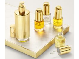 site-industries-cosmetiques Una colección de productos de lujo para el cuidado de la piel con toques dorados sobre una superficie revestida de mármol, con frascos de diferentes tamaños. Este finalista de los Innovation Awards 2025 incluye cuentagotas y un frasco pulverizador, con líquidos de color amarillo dorado que seguro cautivarán en la Semana del Embalaje de París.