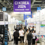site-industries-cosmetics 参观者在贸易展的展台上漫步，"CI KOREA 2024 "的字样就挂在展台的横幅上。在标有 "CI KOREA 2024 "字样的展区中，一个汽车展吸引了人们的目光，为整个展区增添了创新和热情的活力。