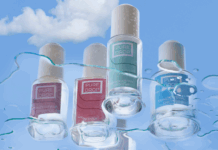 site-industries-cosmetiques 四瓶不同颜色的 Pure Drop 指甲油在云雾缭绕的蓝天下格外显眼，水珠和条纹点缀其中。这幅图片彰显了该品牌对化妆品包装负责任的承诺。