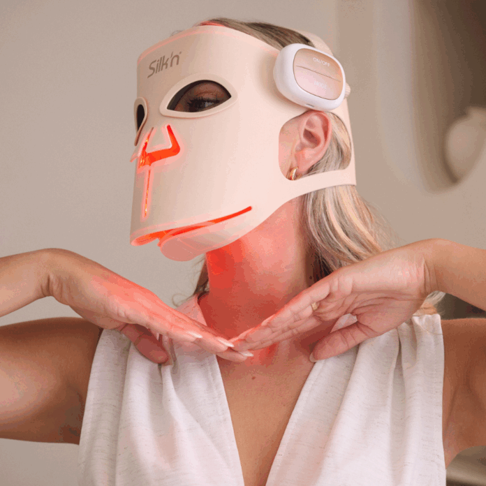 site-industries-cosmetiques Une personne portant un haut blanc sans manches et un masque de luminothérapie à LED dont la marque 