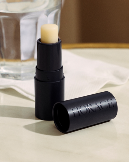 89d249f2-2815-4cef-bc1b-d9255c2454e6 site-industries-cosmetiques A black tube of lip balm with the brand