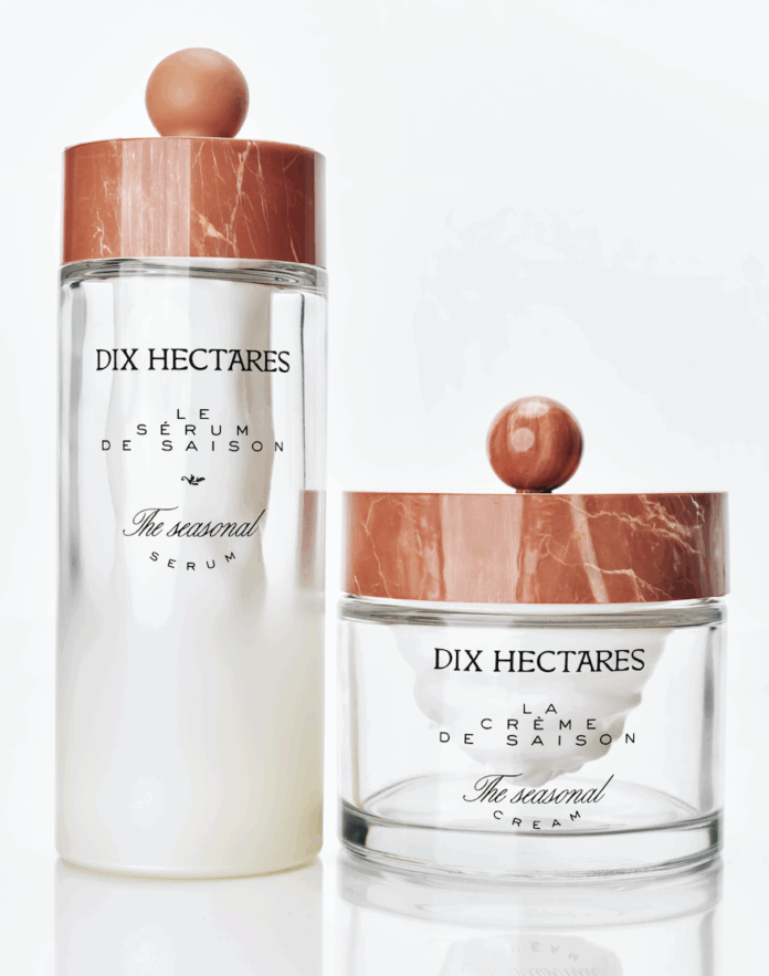 site-industries-cosmetiques Sobre una superficie blanca se exponen dos envases de cristal de productos para el cuidado de la piel de Dix Hectares. Uno es un frasco grande de suero y el otro un tarro pequeño de crema. Ambos tienen tapas con motivos de mármol y etiquetas con texto en negro.
