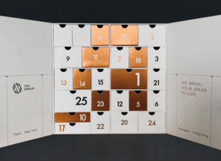 site-industries-cosmetiques TNT 集团的一款白色圣诞日历盒，以金属铜色和白色为底色的编号抽屉呈网格状排列，展示了其在特殊包装方面的专业技术。每个盖子的底部都标有城市名称。.