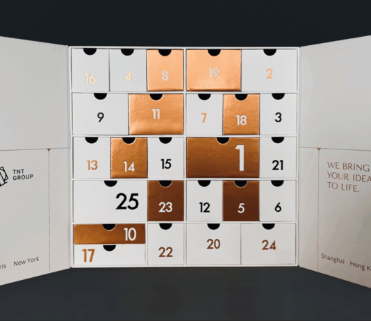 site-industries-cosmetiques Uma caixa de calendário do advento branca do Grupo TNT, com gavetas numeradas em cobre metálico e branco dispostas em grelha, demonstra a sua experiência em embalagens excepcionais. Os nomes das cidades estão indicados na parte inferior de cada aba.