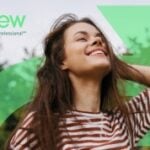 site-industries-cosmetiques A woman with long brown hair, wearing a striped shirt, stands outside smiling, eyes closed. The words "ReNew by Kimberly-Clark Professional" appear in the top left-hand corner on a green graphic.