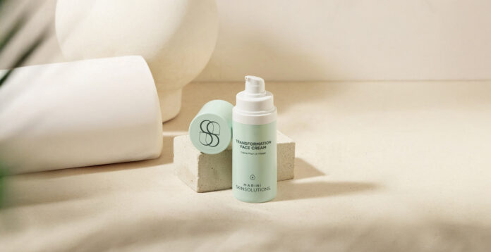 site-industries-cosmetiques Um frasco de creme facial SVRANI Skin Solutions Transformation com doseador está colocado num bloco de pedra de cor clara, juntamente com a sua tampa destacada, sobre um fundo neutro com sombras suaves.