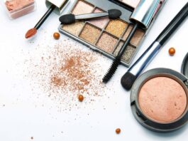 site-industries-cosmetiques 在白色表面上散落着各种化妆产品，包括眼影盘、口红涂抹器、腮红盒、睫毛膏棒、粉饼和化妆粉。.