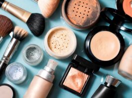 site-industries-cosmetiques 浅蓝色的表面上陈列着各种化妆产品和化妆刷。产品包括散粉和粉饼、粉底液、荧光笔、眼影盒和几支化妆刷。.