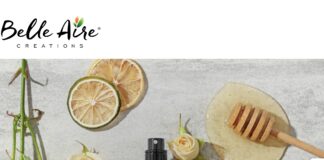site-industries-cosmetiques Belle Aire Creations 的标志位于干柑橘片、白玫瑰、黑色喷雾瓶和蜂蜜勺的平面展示上方，浅灰色的表面彰显了其在北美的强大影响力。.