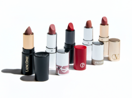 site-industries-cosmetiques 六支来自不同奢侈品牌的口红，每支都没有盖子，放在管子旁边。从左到右依次为兰蔻、香奈儿、爱马仕、乔治-阿玛尼、普拉达和华伦天奴。.