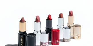site-industries-cosmetiques Six rouges à lèvres de différentes marques de luxe, chacun décapsulé et placé à côté du tube. Les marques visibles sont Lancôme, Chanel, Hermès, Giorgio Armani, Prada et Valentino, de gauche à droite.