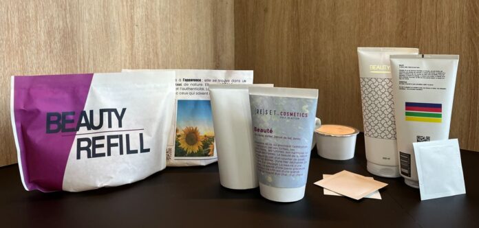 site-industries-cosmetiques 一组美容产品容器，包括软管、罐子、蜡烛、折叠包和贴有标签的补充装袋 