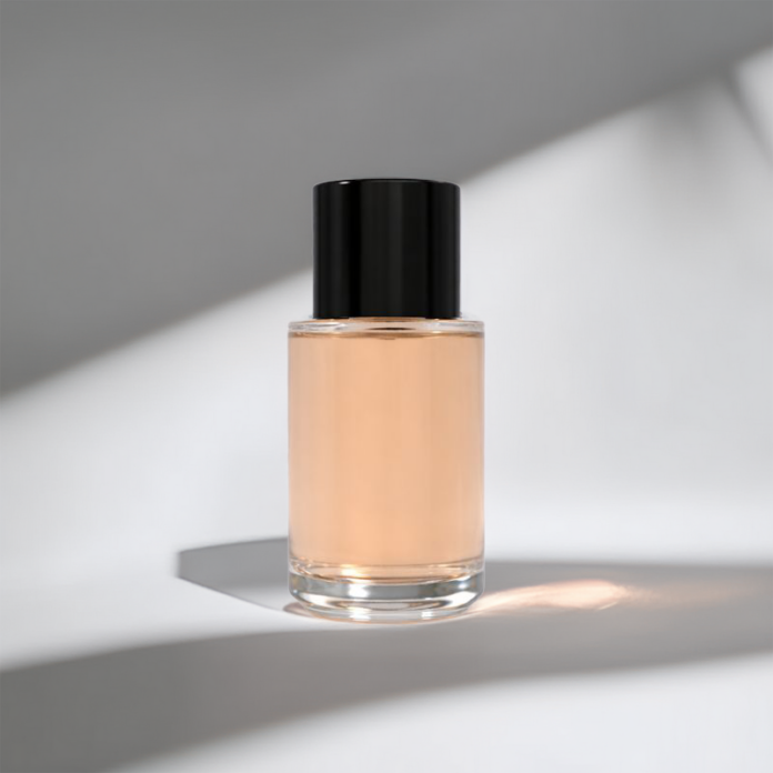site-industries-cosmetiques 一个透明的玻璃瓶，里面装满了透明的桃红色液体，瓶口有一个闪亮的黑色瓶盖，放置在一个有光影角度的白色表面上。.