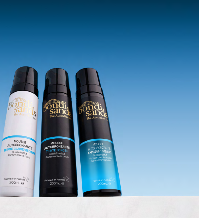 site-industries-cosmetiques Trois bouteilles de mousse autobronzante Bondi Sands de différentes variétés se trouvent côte à côte sur une surface blanche avec un fond de ciel bleu clair. Chaque bouteille a une contenance de 200 ml et présente un étiquetage et des couleurs distincts.
