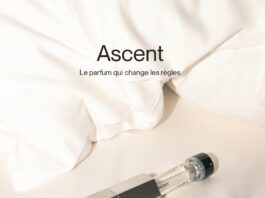 site-industries-cosmetiques 柔软的白布上放着一个透明的香水瓶，瓶盖和标签都是深色的。上面写着 "Ascent，改变规则的香水"。附加文字描述了这款香水的特性：中性、可续装、无公害和纯素。.