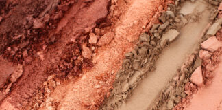 site-industries-cosmetiques 粉红色、桃红色、古铜色和米色的碎化妆粉特写，这些化妆粉呈粗糙的平行条状排列，粉质厚重。.