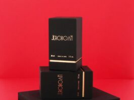 site-industries-cosmetiques 三个黑色杰罗波安香水罐呈长方形，金色字体，堆叠在红色背景的红色表面上。最大的罐子在底部，最小的标有 "30 毫升 "字样，在顶部。.